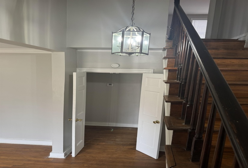 Staircase featuring a chandelier and wood finished floors