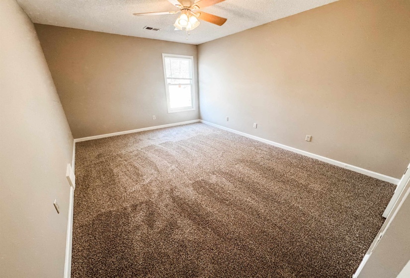 Carpeted spare room with a textured ceiling and a ceiling fan