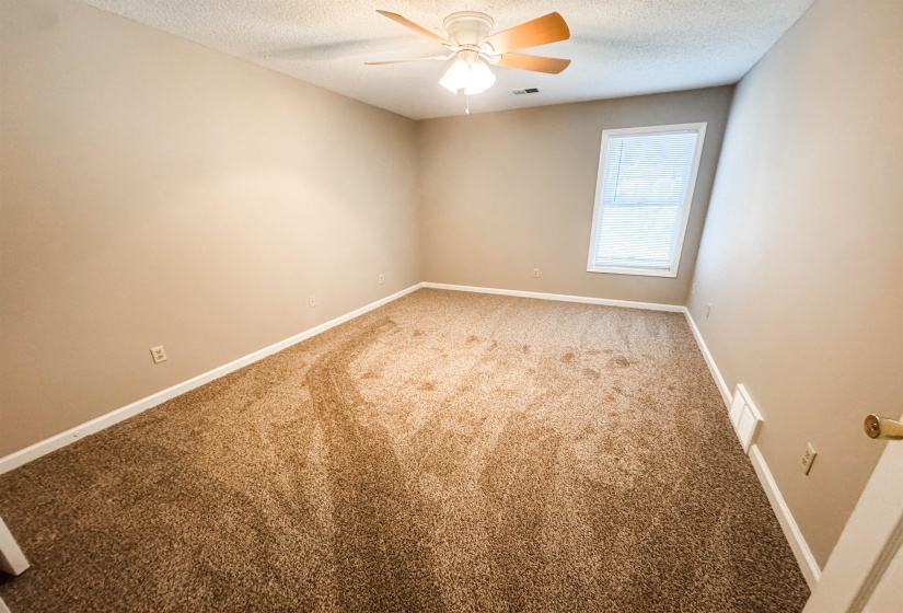 Carpeted empty room with baseboards and a textured ceiling