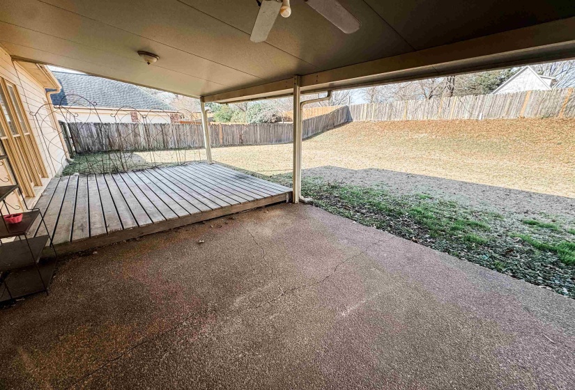 Fenced backyard with ceiling fan, a patio, and a deck
