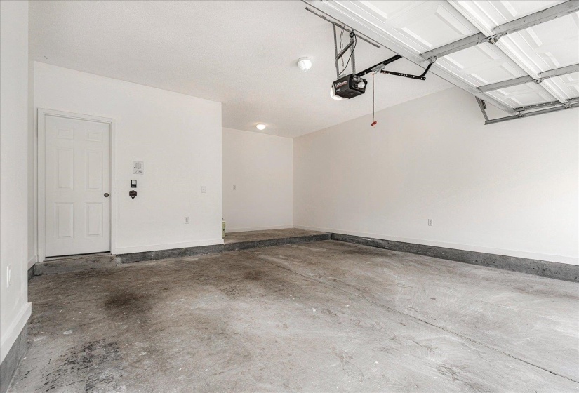 Garage with baseboards and a garage door opener