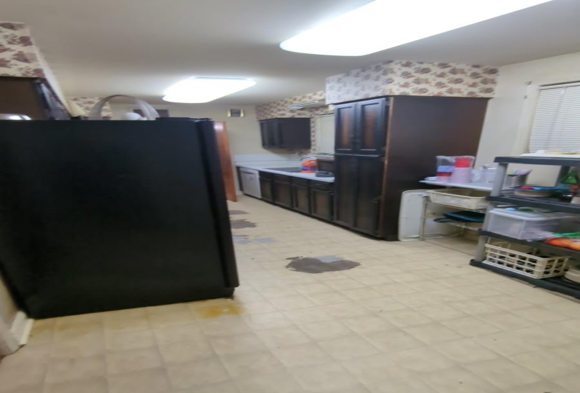Kitchen with freestanding refrigerator, light floors, and light countertops