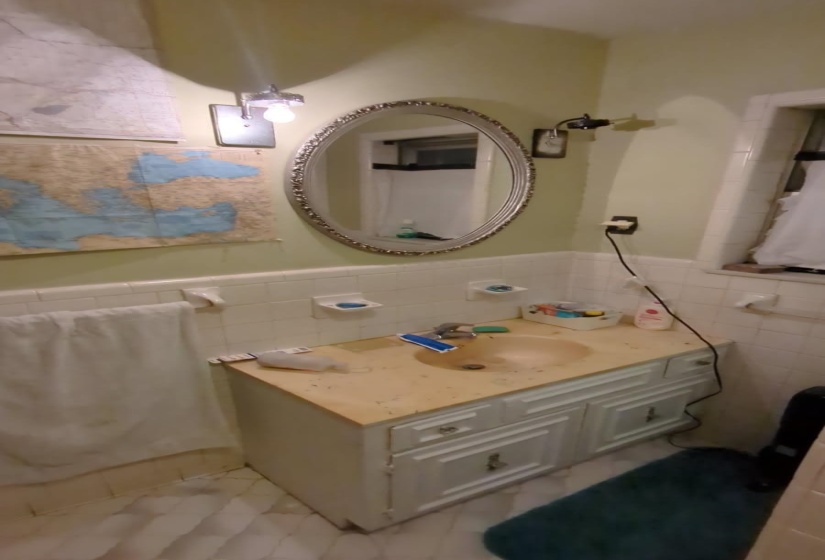Bathroom featuring vanity, tile walls, and wainscoting
