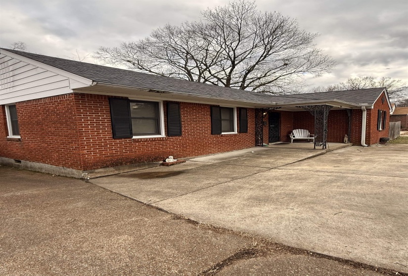 View of side of home with brick siding, roof with shingles, and crawl space