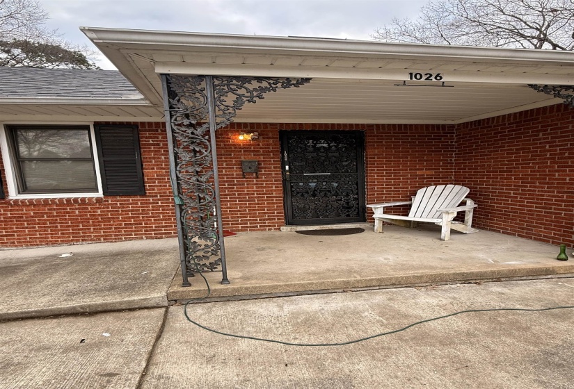 View of exterior entry featuring a patio and brick siding