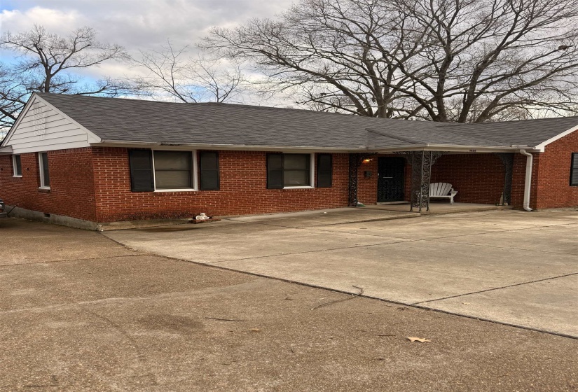 Ranch-style home with brick siding, roof with shingles, driveway, and crawl space