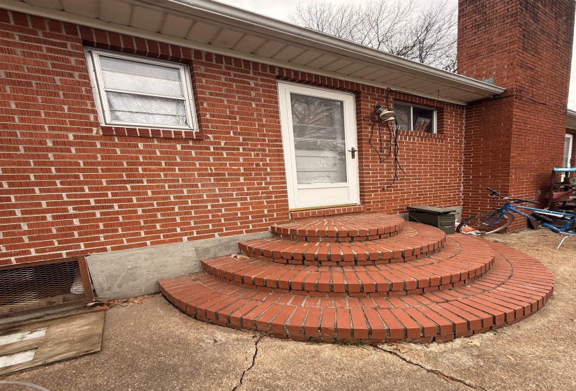 Doorway to property with brick siding