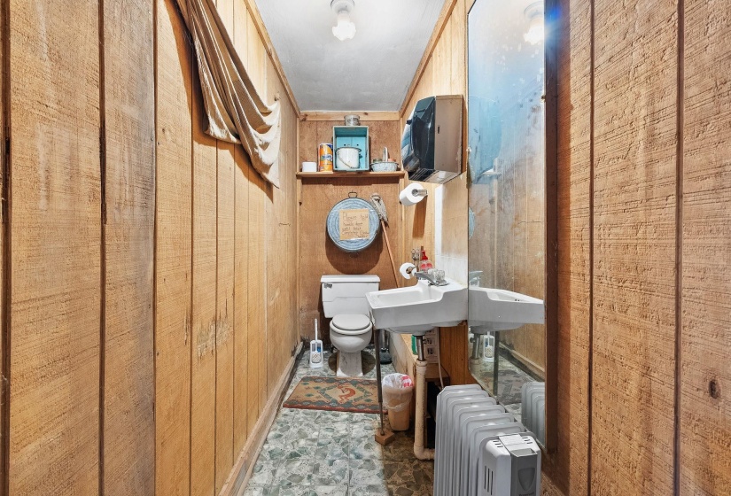 Bathroom featuring wood walls and radiator heating unit