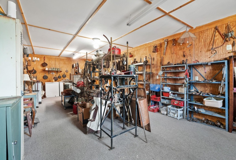 Garage with wood walls, a workshop area, and white refrigerator