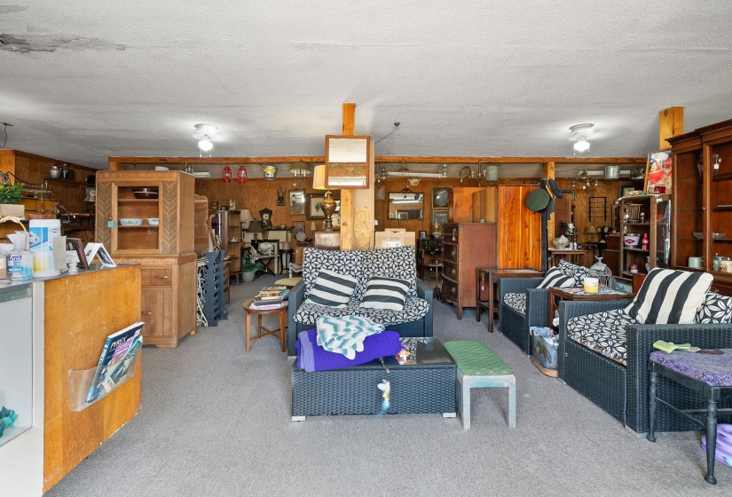 Living room featuring wood walls, a textured ceiling, and light carpet