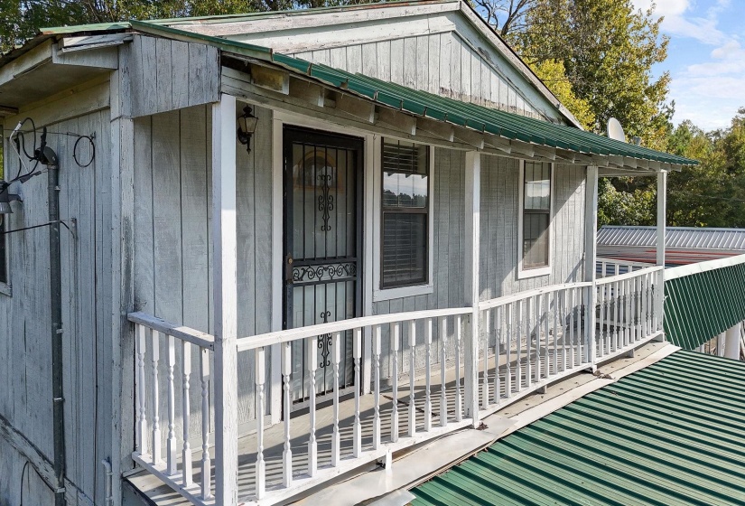 View of side of home featuring a metal roof and covered porch