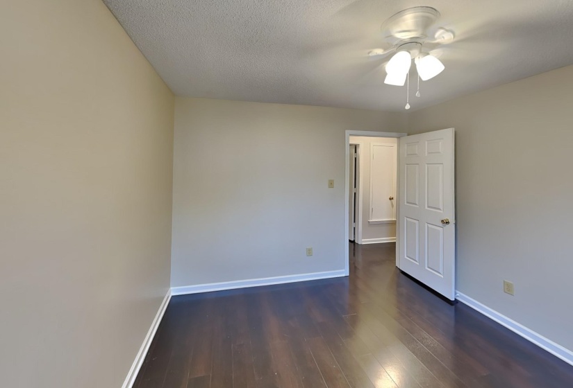 Unfurnished room with dark wood-type flooring, a textured ceiling, and ceiling fan