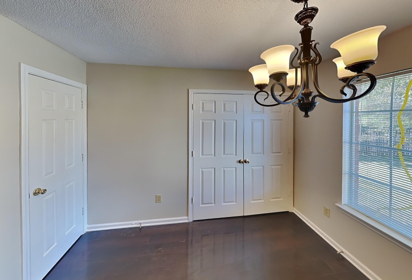 Unfurnished dining area featuring a chandelier, a textured ceiling, and dark hardwood / wood-style floors