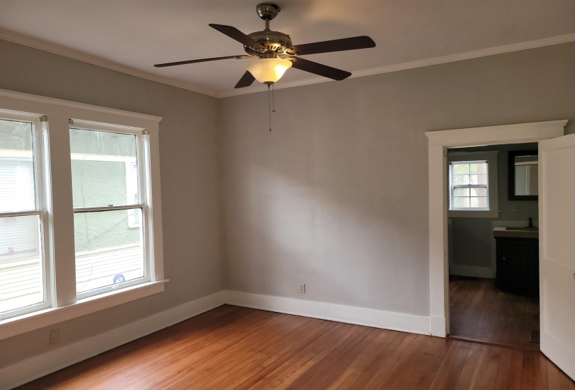 Spare room with hardwood / wood-style flooring, ornamental molding, and a ceiling fan