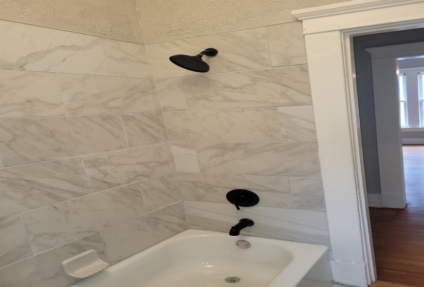 Full bathroom with shower / bathtub combination and wood finished floors