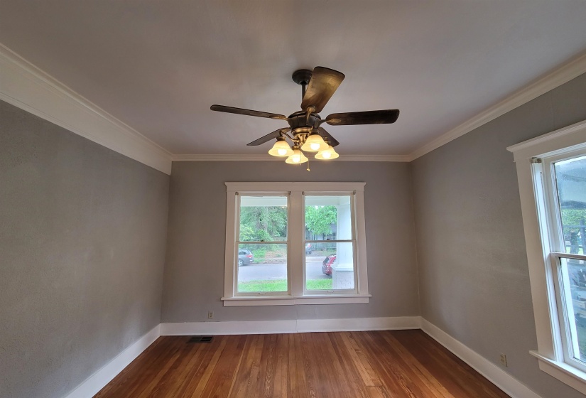 Spare room featuring ceiling fan, wood finished floors, and ornamental molding