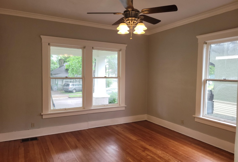 Spare room with crown molding, wood finished floors, and a ceiling fan