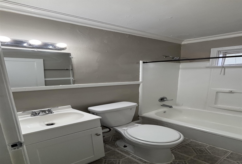 Full bath featuring shower / tub combination, vanity, tile patterned floors, and ornamental molding