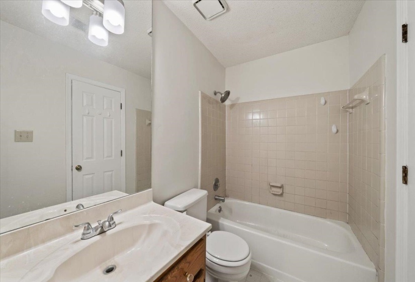 Bathroom with vanity,  shower combination, and a textured ceiling
