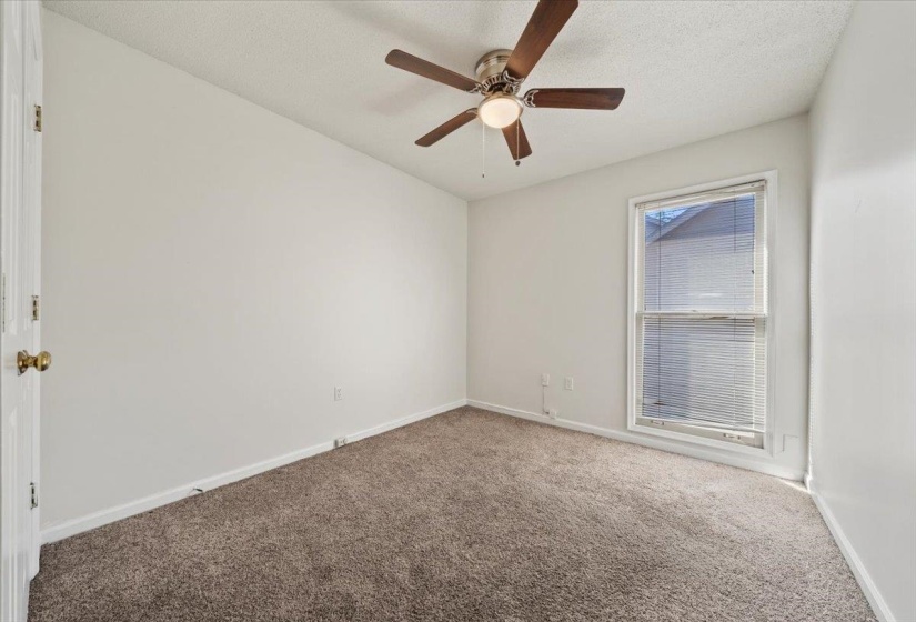 Carpeted spare room with a textured ceiling and ceiling fan