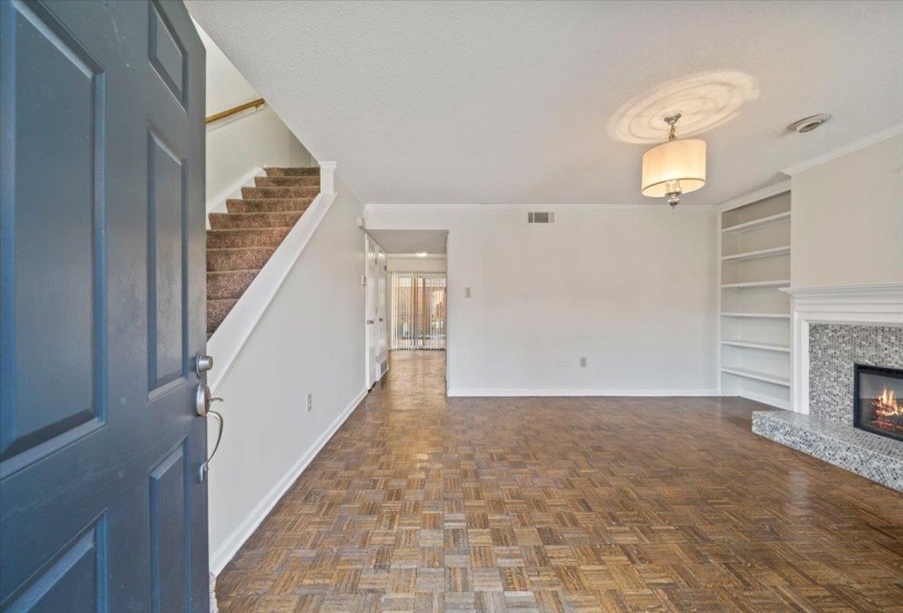 Entryway featuring a textured ceiling, a high end fireplace, crown molding, and stairway