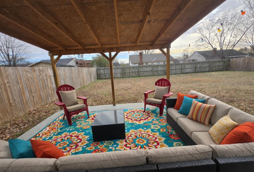 Fenced backyard with an outdoor hangout area and a patio