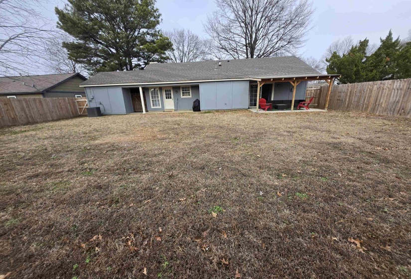 Back of property featuring a fenced backyard, a patio area, and a shingled roof