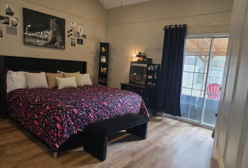 Bedroom featuring access to exterior, wood finished floors, and lofted ceiling
