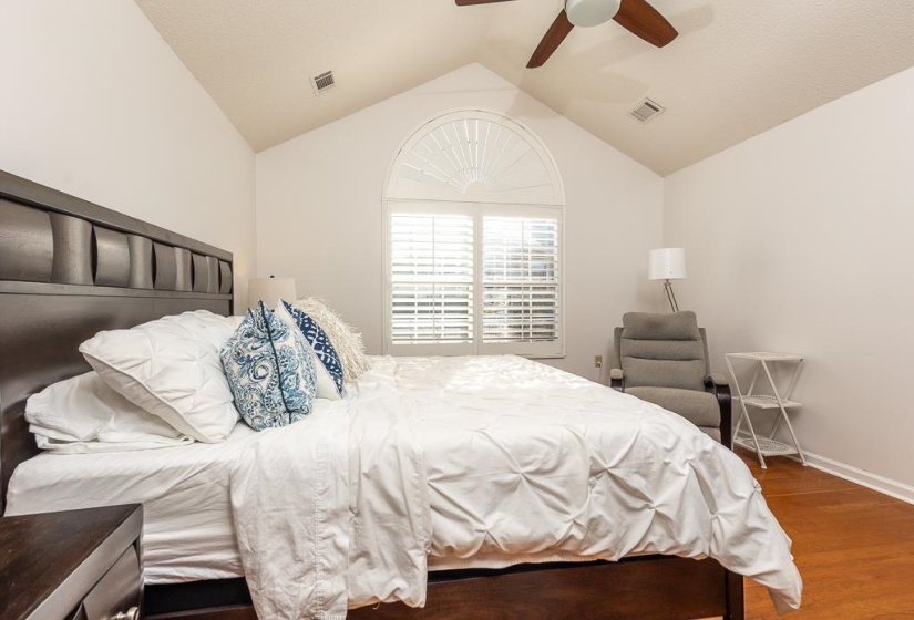 Bedroom with wood finished floors, vaulted ceiling, and a ceiling fan