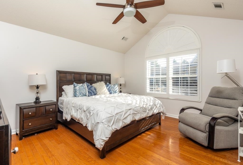 Bedroom featuring vaulted ceiling, light wood finished floors, and ceiling fan