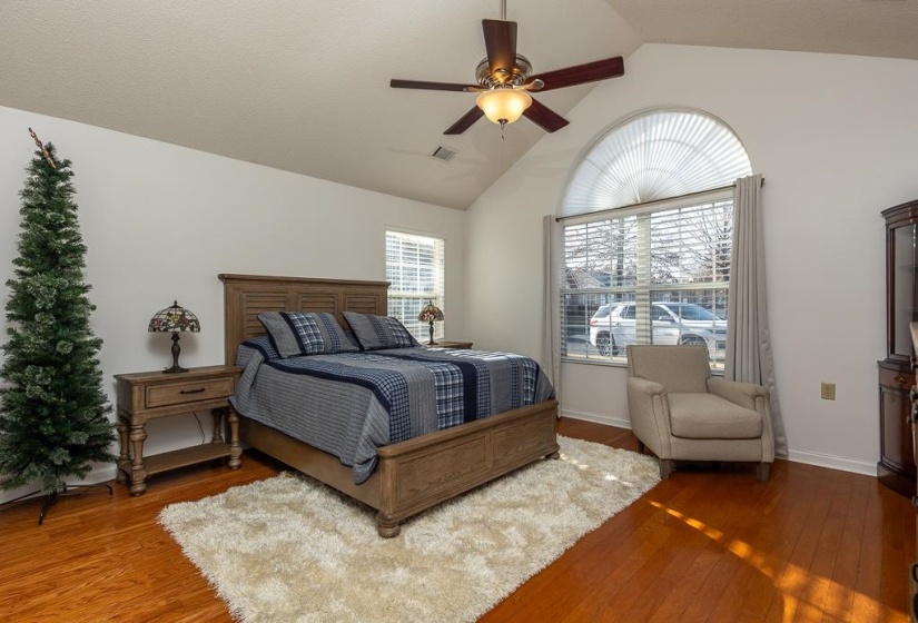 Bedroom with vaulted ceiling, hardwood / wood-style floors, and a ceiling fan