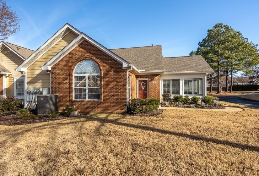 Ranch-style home featuring brick siding, a front lawn, and a shingled roof