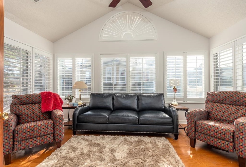 Living area with vaulted ceiling, wood finished floors, and ceiling fan