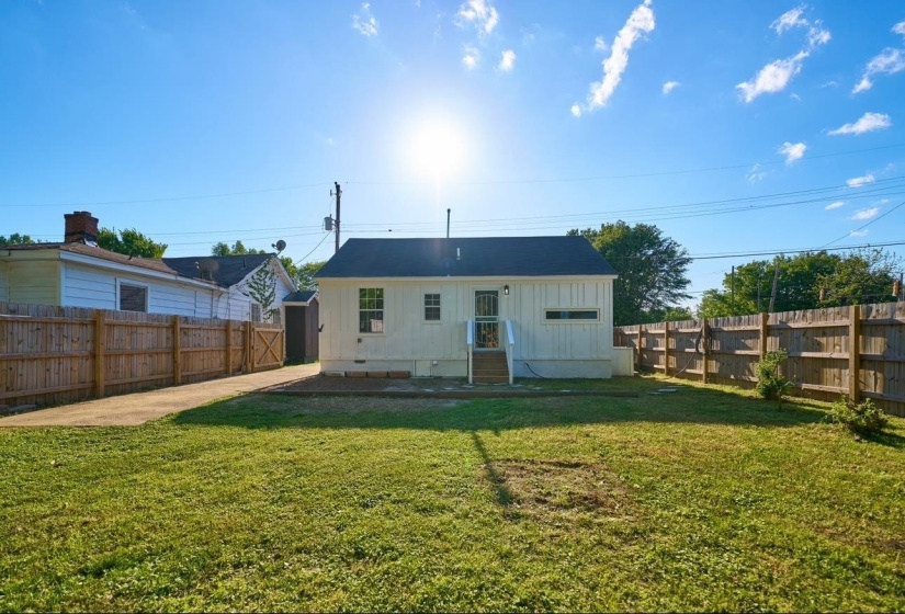 Back of house with board and batten siding and a fenced backyard