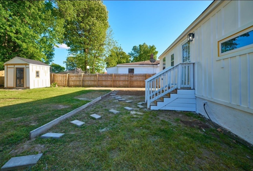Fenced backyard with a storage unit