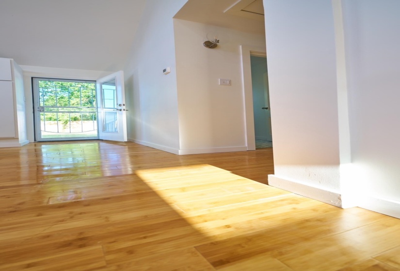 Unfurnished room with light wood-style floors and lofted ceiling