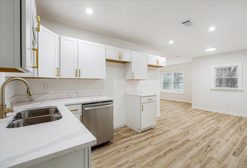 Kitchen featuring recessed lighting, dishwasher, light wood-style floors, white cabinetry, and light stone countertops