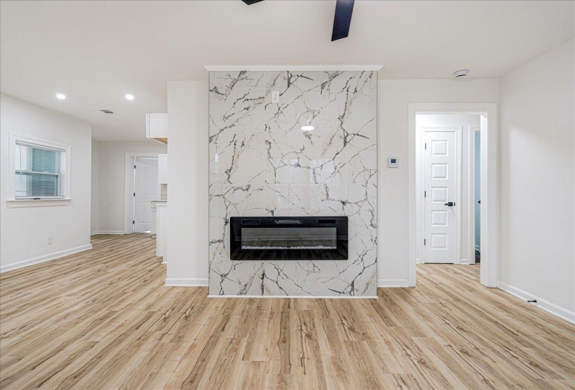 Unfurnished living room with a fireplace, light wood-style floors, ceiling fan, and recessed lighting