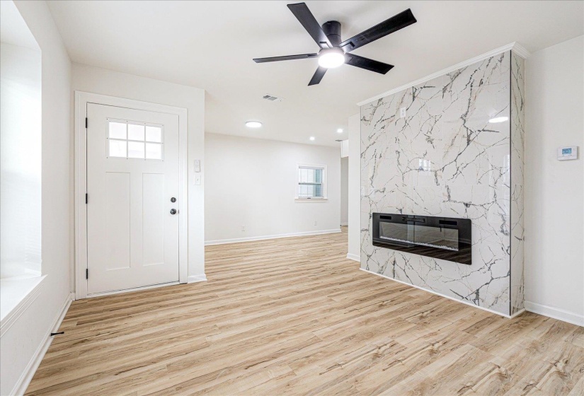Unfurnished living room with a fireplace, light wood-type flooring, ceiling fan, and recessed lighting