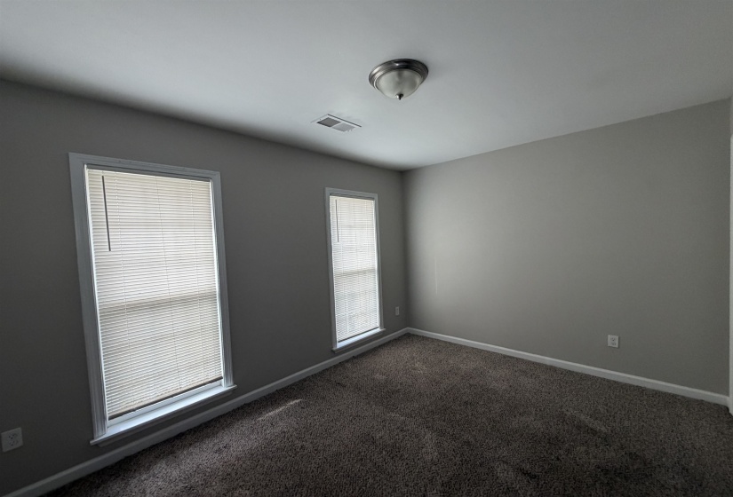 Unfurnished room with dark colored carpet and baseboards