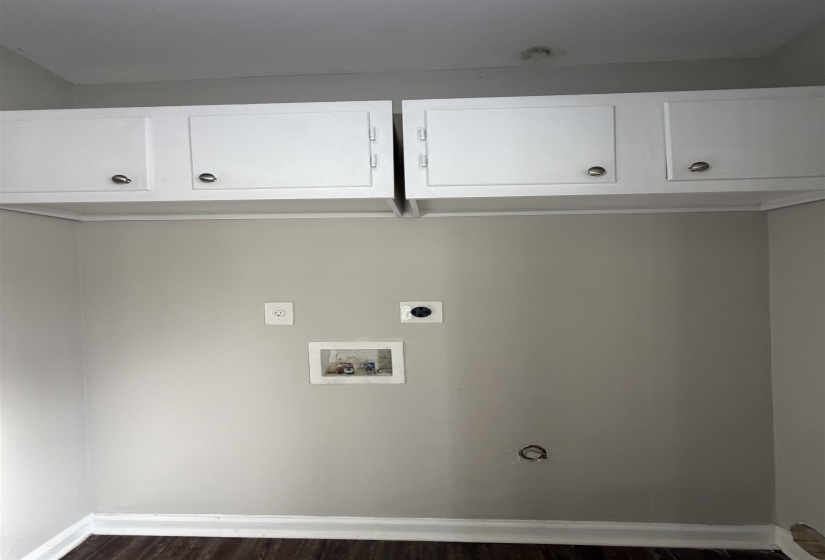 Laundry area featuring cabinet space, dark wood-style flooring, hookup for a washing machine, and electric dryer hookup