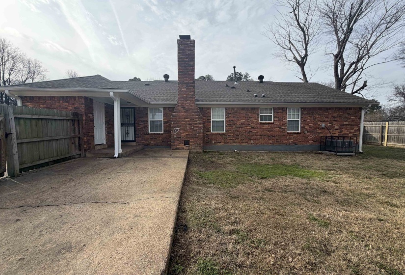 Rear view of house with a patio, roof with shingles, a chimney, and brick siding