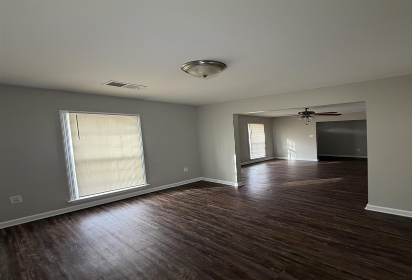 Unfurnished room featuring a ceiling fan and dark wood-style floors