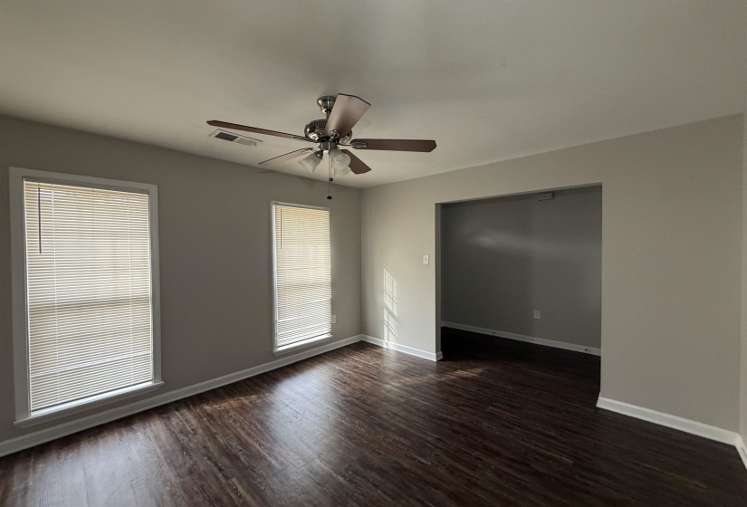Unfurnished room featuring dark wood-style flooring and ceiling fan