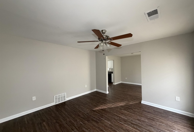 Spare room featuring dark wood-type flooring and a ceiling fan