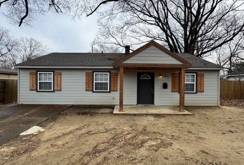 Ranch-style house featuring a shingled roof and covered porch