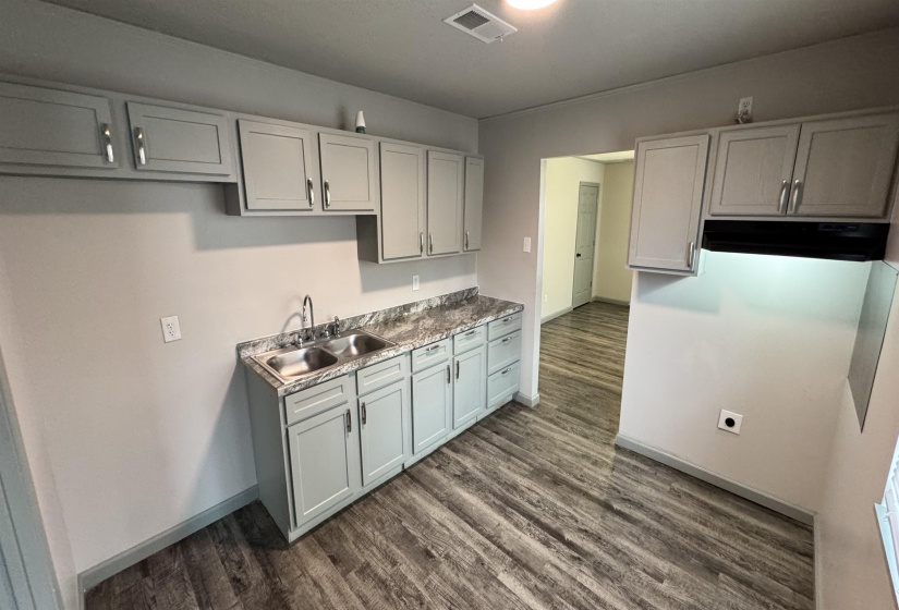 Kitchen featuring under cabinet range hood and dark wood finished floors