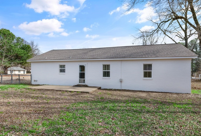 Back of property featuring a patio and a shingled roof
