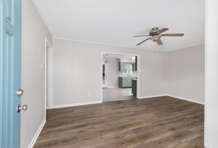 Spare room featuring dark wood finished floors, a ceiling fan, and a chandelier