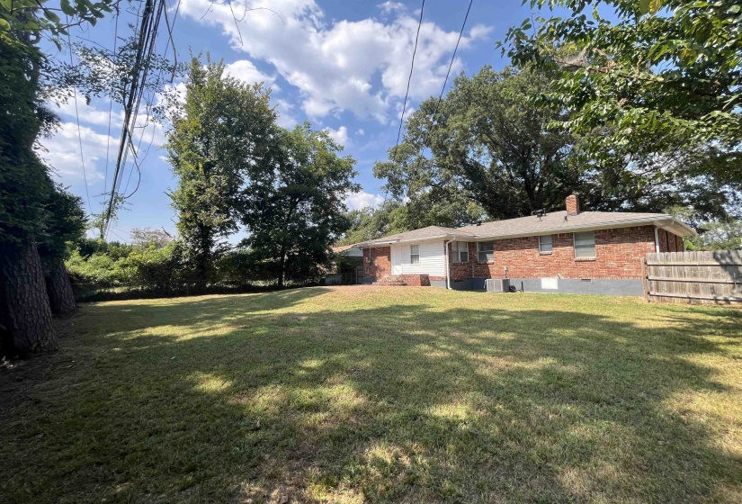 Rear view of house featuring brick siding, a chimney, and crawl space